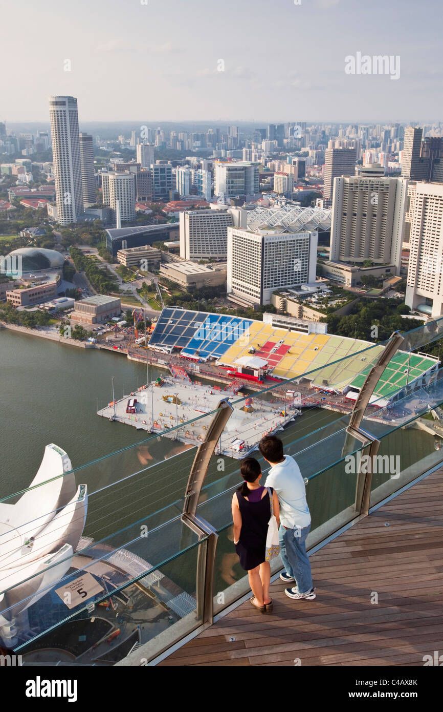 Singapour, Singapour, Marina Bay. Un couple s'ouvrent sur la ville depuis le pont d'observation de la Marina Bay Sands SkyPark. Banque D'Images