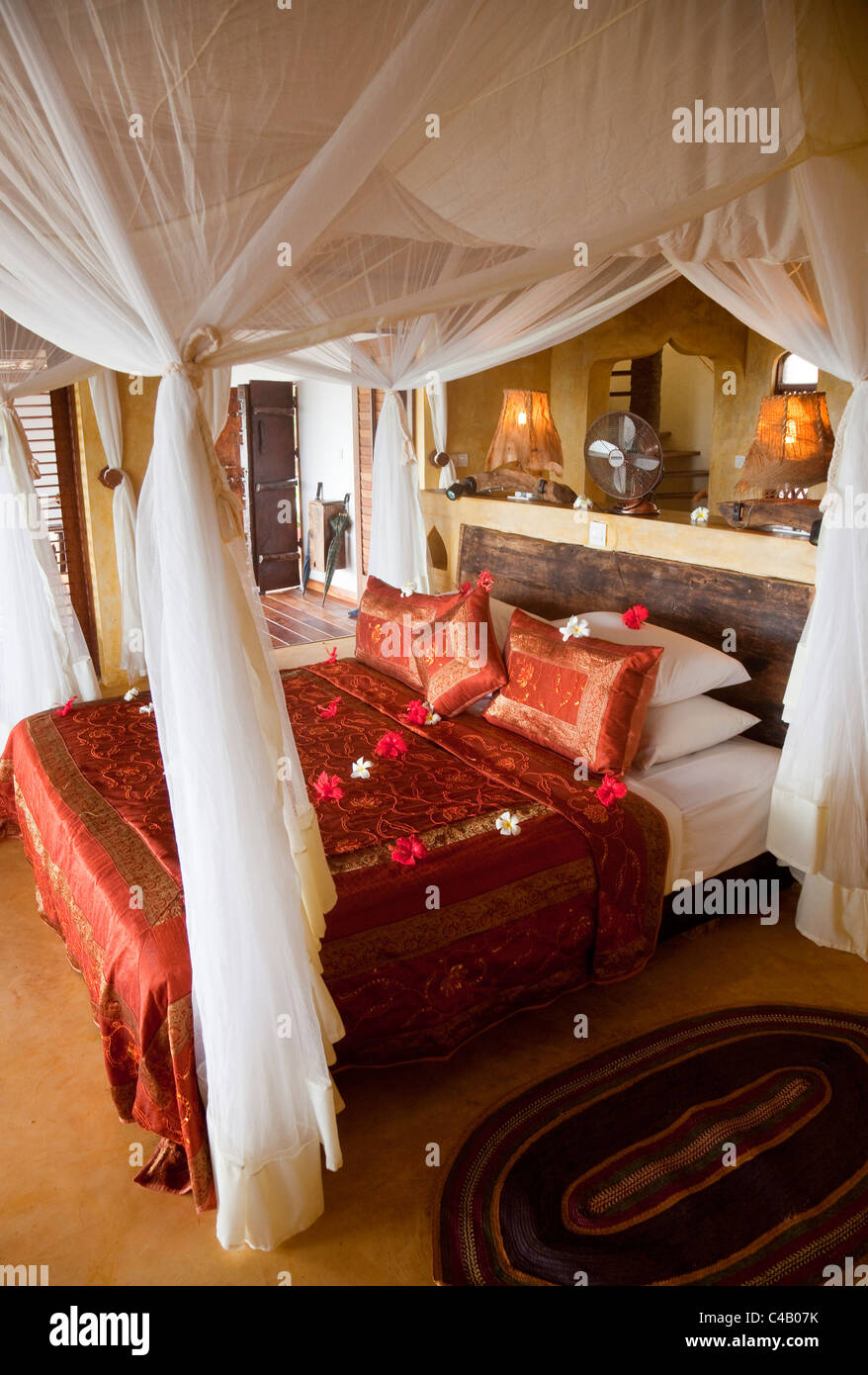 Zanzibar, Matemwe Bungalows. Un lit à baldaquin au centre d'un de Matemwe's luxury suites. Banque D'Images