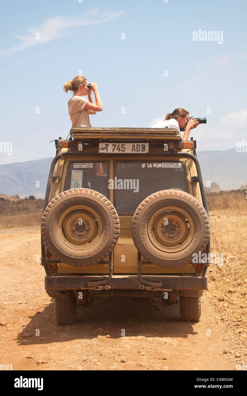 La Tanzanie, le Ngorongoro. Deux femmes regarder dehors à partir d'un véhicule de safari à la faune. Banque D'Images