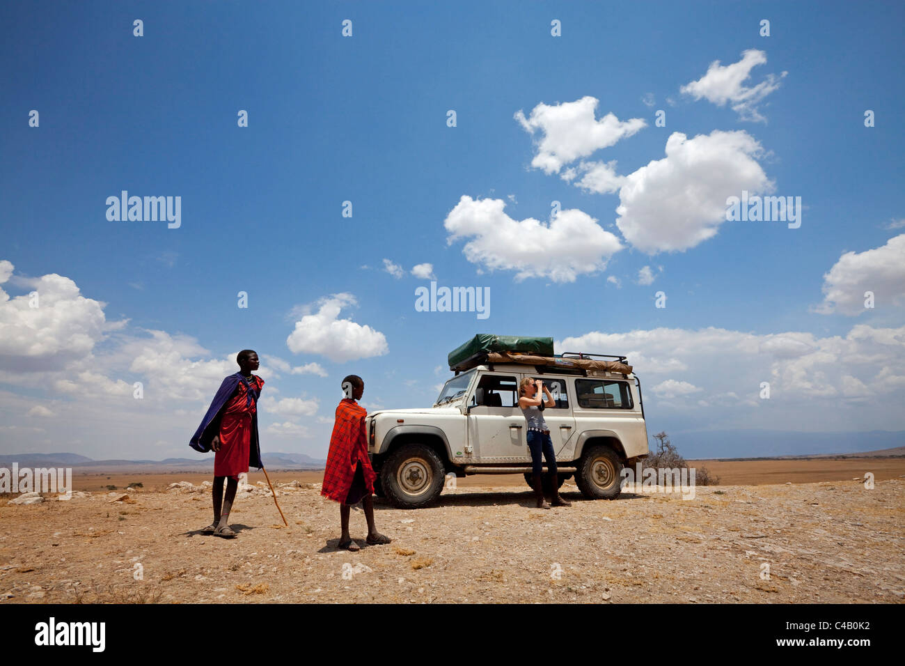 D'Olduvai en Tanzanie. Enfants massaïs watch en tant que touriste donne sur le paysage autour de la gorge d'Olduvai. M. Banque D'Images