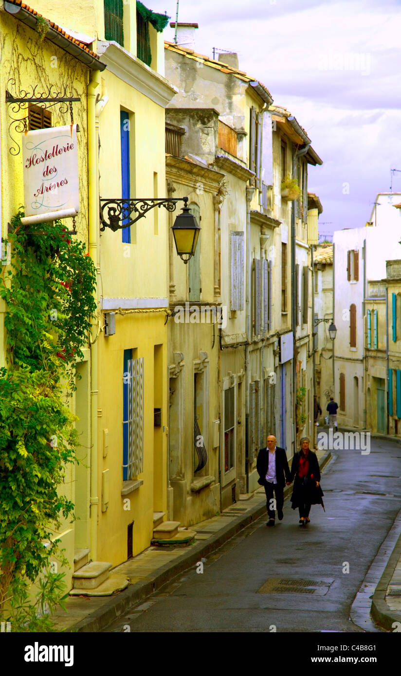 Arles, Bouches du Rhône, France ; un couple en train de marcher dans une rue typique de la ville Banque D'Images