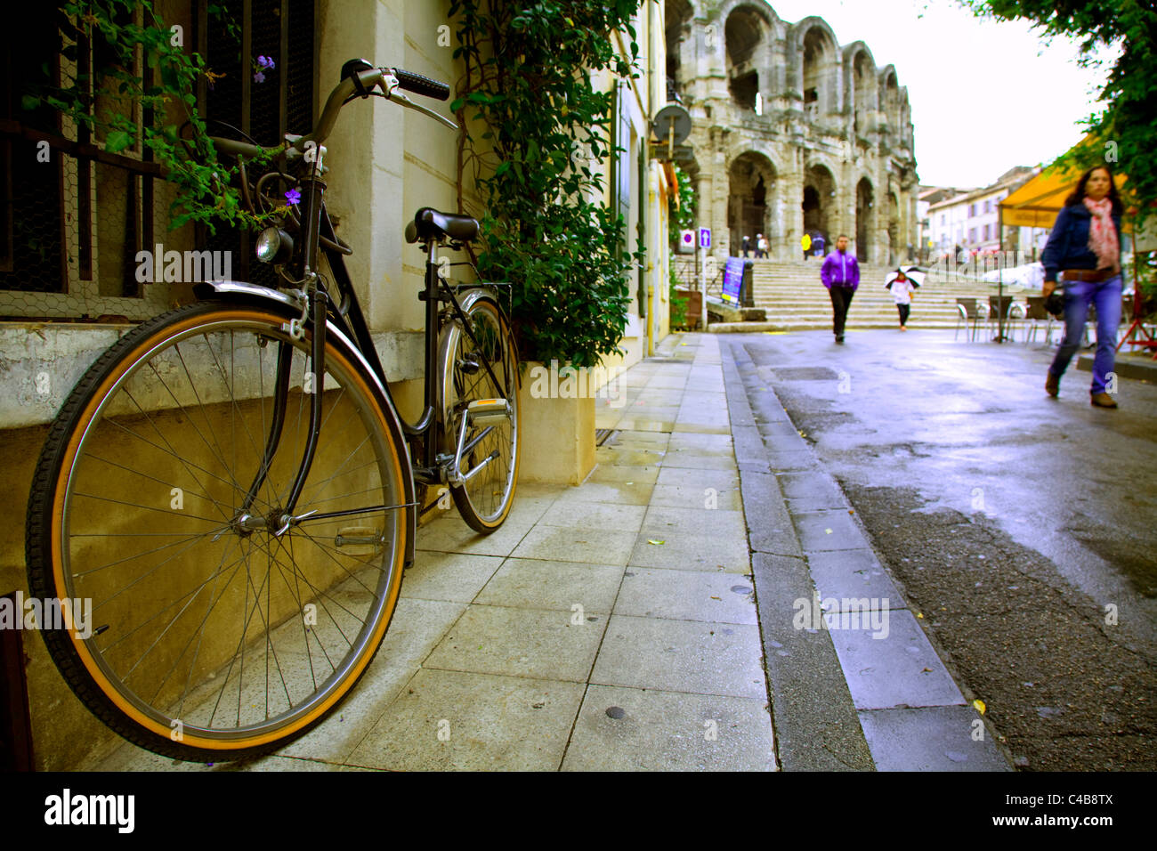 Arles, Bouches du Rhône, France ; un vélo garé sur la rue menant à la place de l'arène romaine Banque D'Images