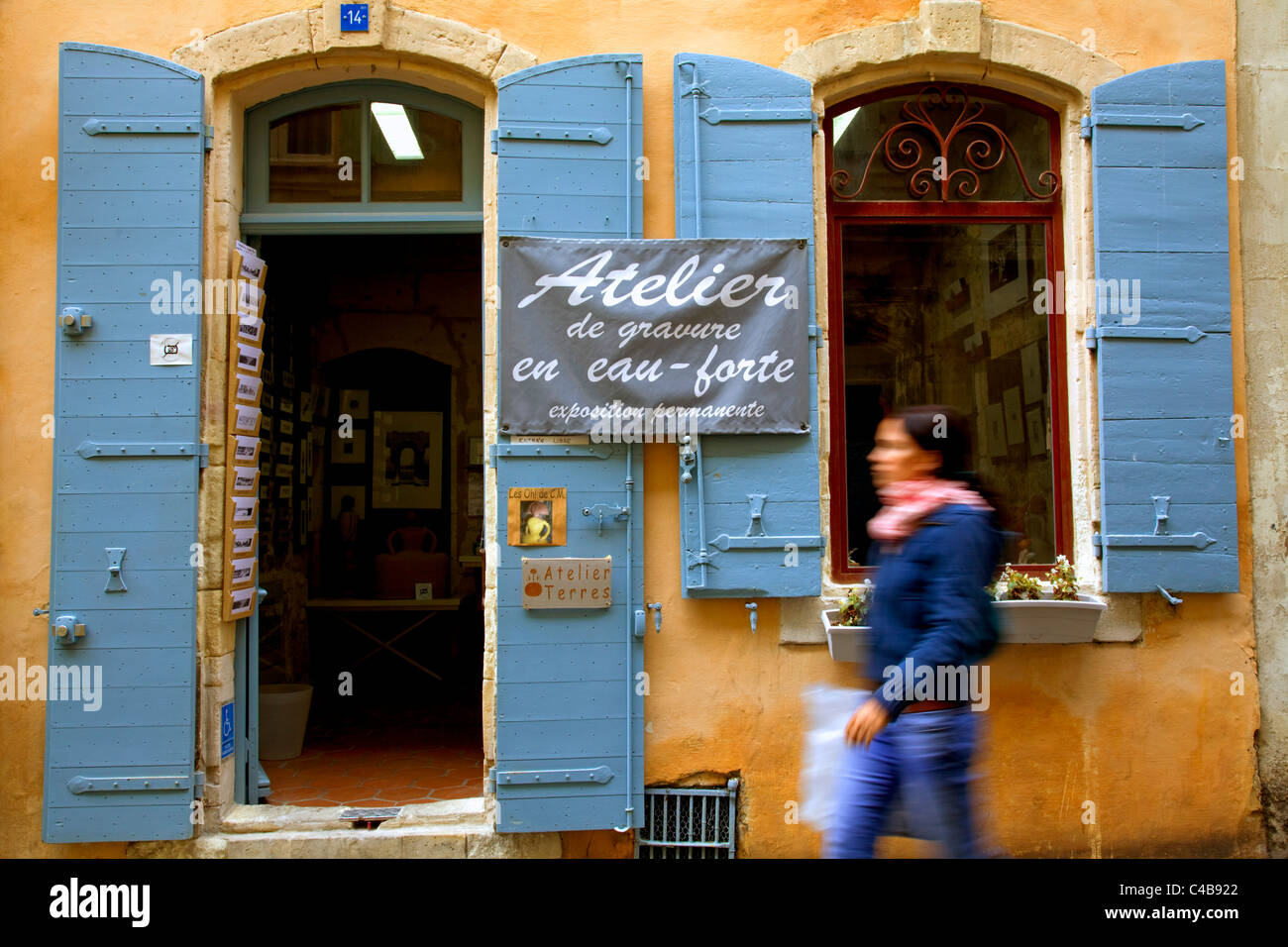 Arles, Bouches du Rhône, France ; une jeune femme marchant devant un Atlelier (du studio d'artiste). M. Banque D'Images