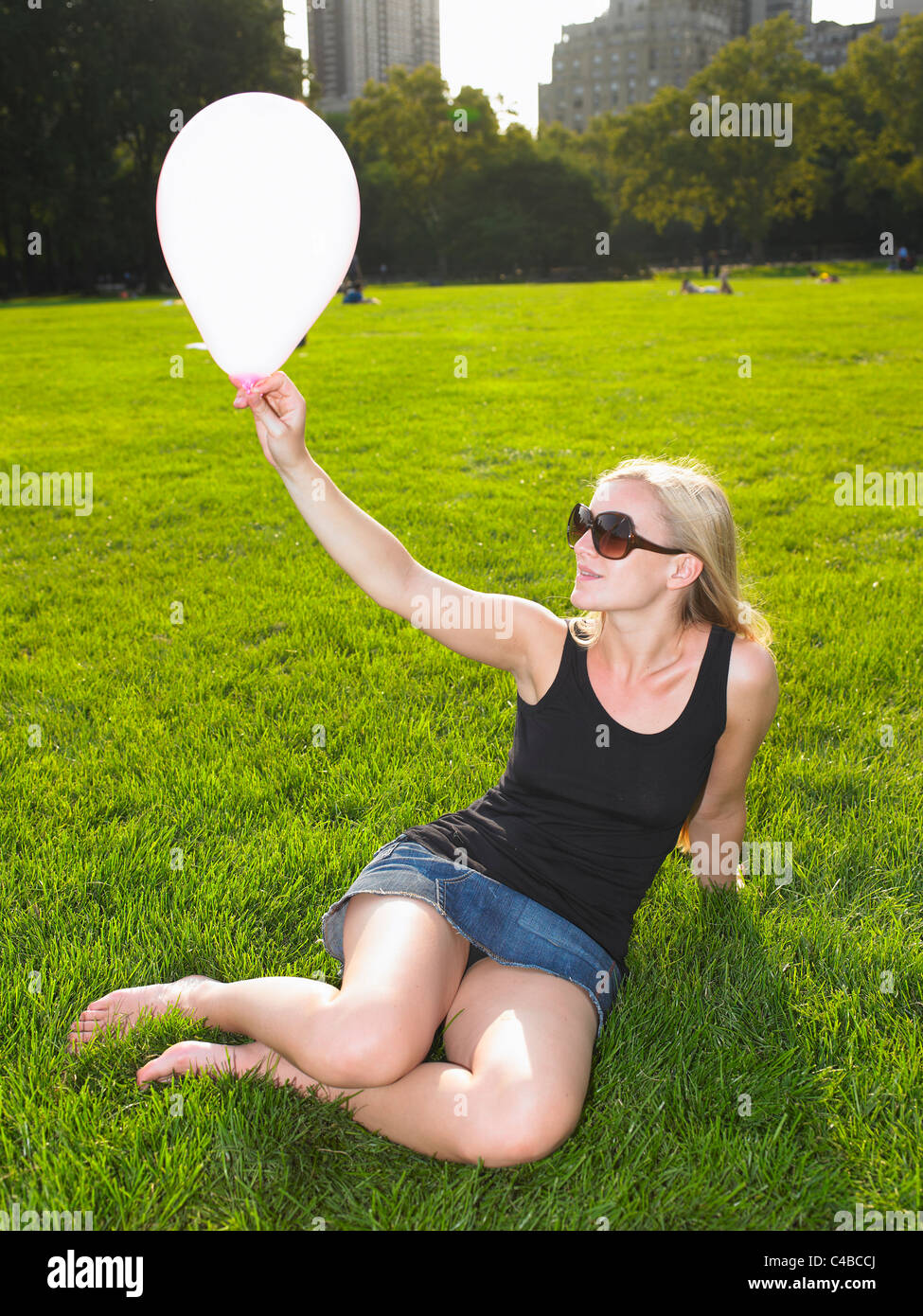 Femme jouant avec un ballon dans un parc Banque D'Images