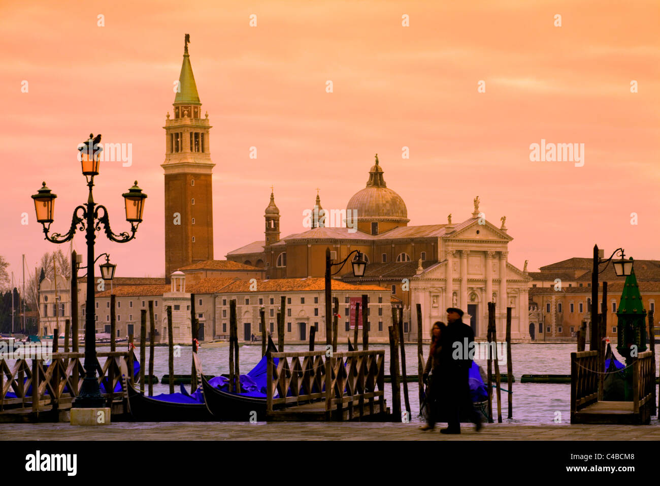 Venise, Vénétie, Italie ; un couple en train de marcher sur le bassin de San Marco onlooking San Giorgio Maggiore Banque D'Images