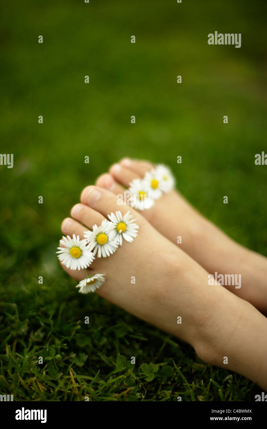 Petite fille de cinq ans avec daisies entre ses orteils Banque D'Images