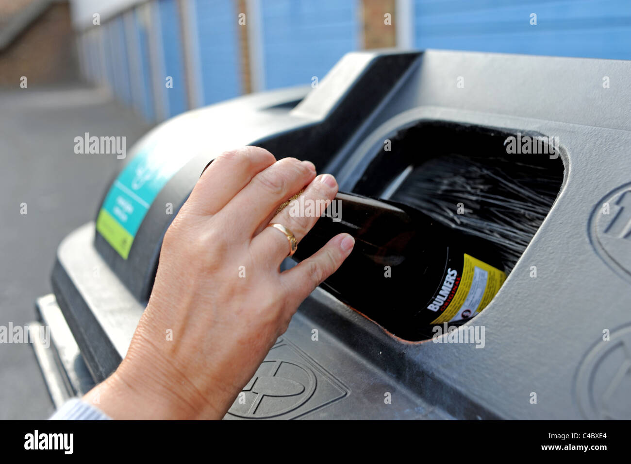 Femme d'âge moyen avec une boîte de bouteilles et boîtes de recyclage au Royaume-Uni Banque D'Images