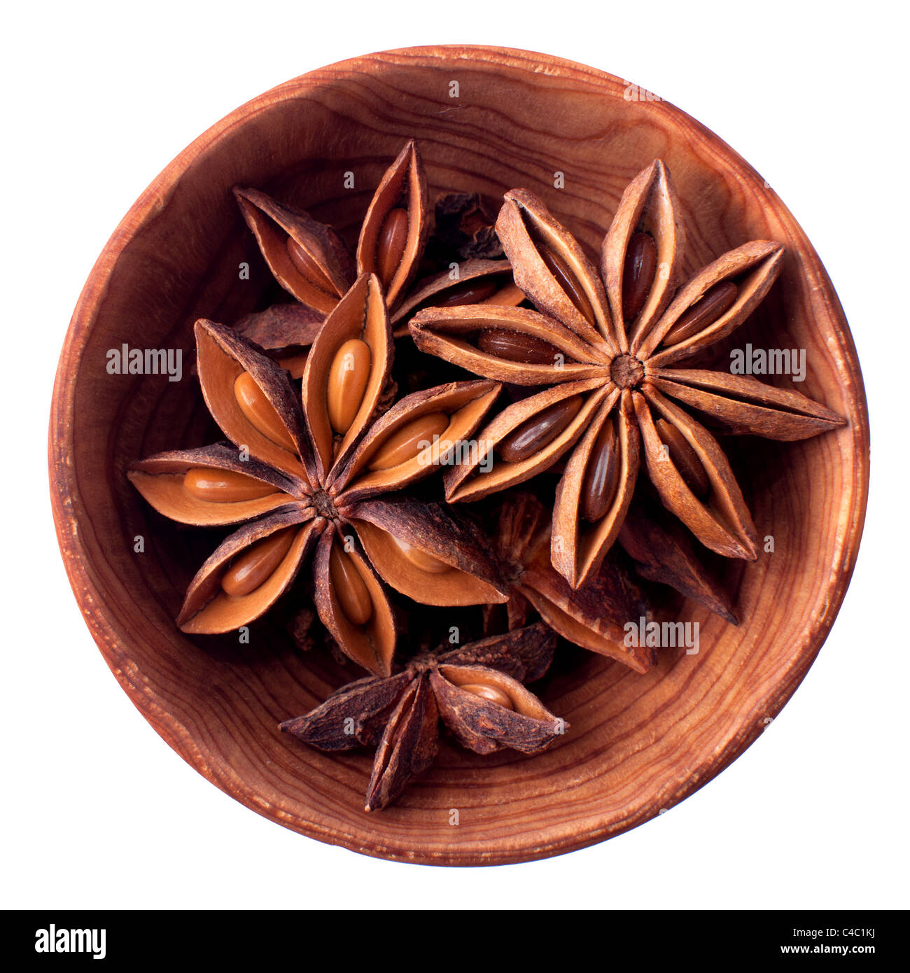 Les étoiles d'anis dans un bol en bois isolé sur blanc Banque D'Images