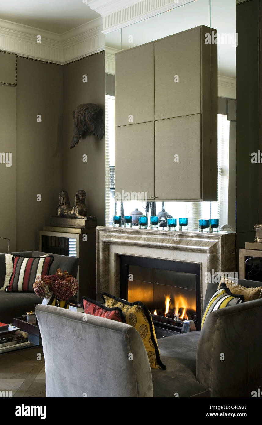 Daim gris banquette-lit dans la salle de séjour avec cheminée et taffetas de soie montés pièce par Dominique Kieffer Banque D'Images