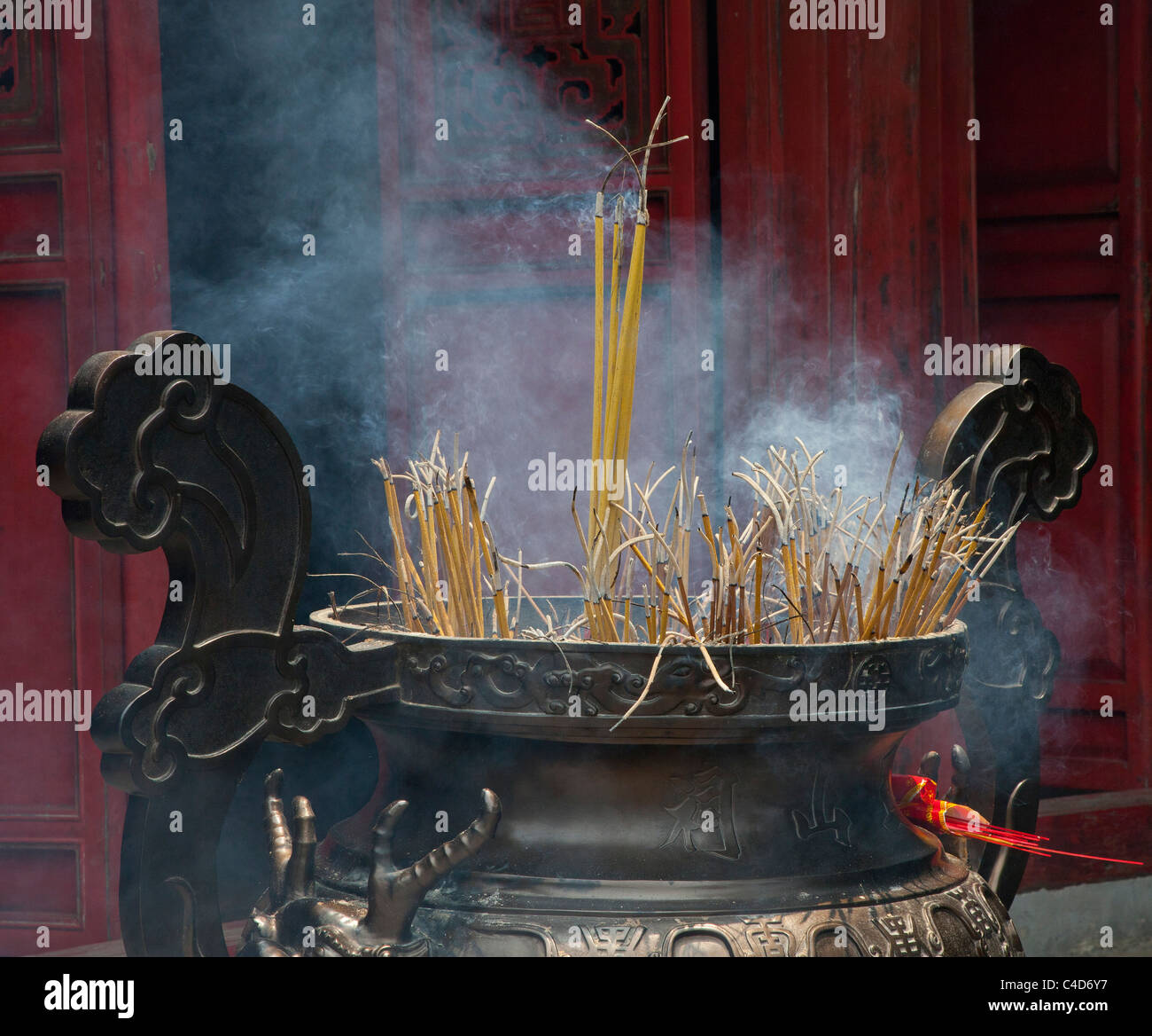 Joss combustion d'encens à l'entrée d'un temple bouddhiste, Vietnam Banque D'Images