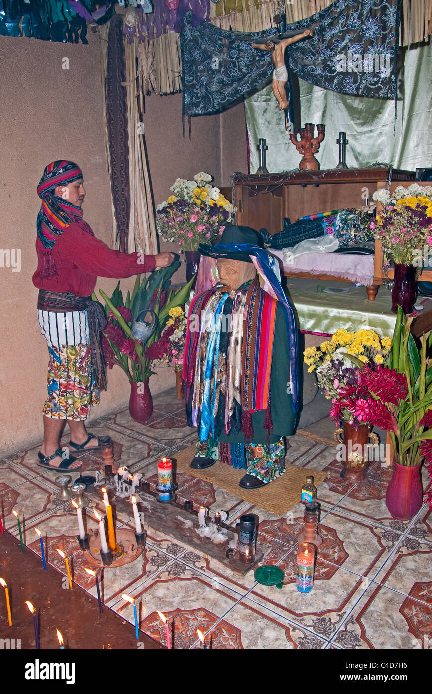 Jeune chaman maya moderne, Nicholas, dans sa maison de Santiago cérémonie rituelle de la scène avec son grand-père figure (centre) Banque D'Images
