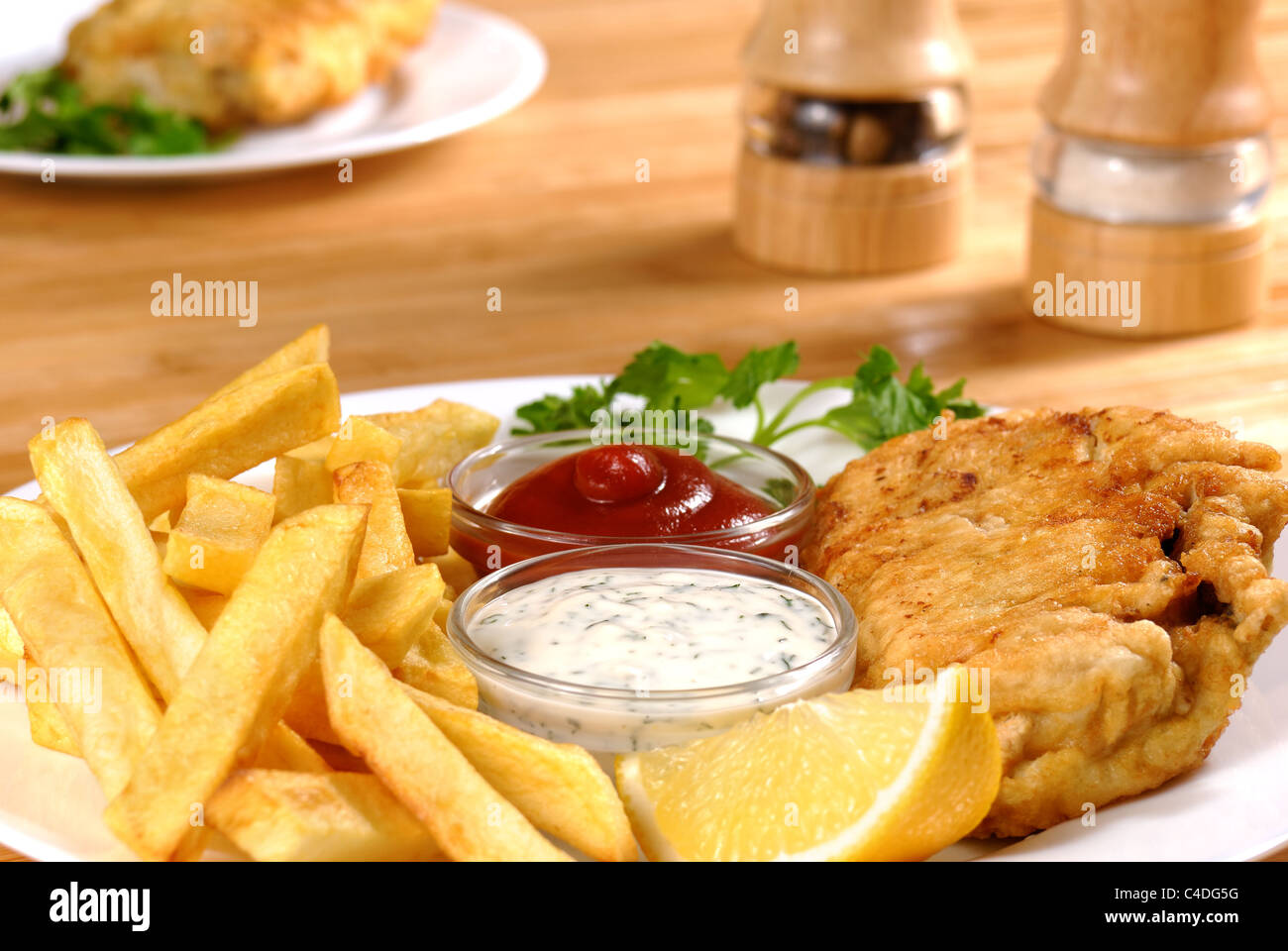 Plaque blanche avec poisson et frites, ketchup et Mayo Banque D'Images