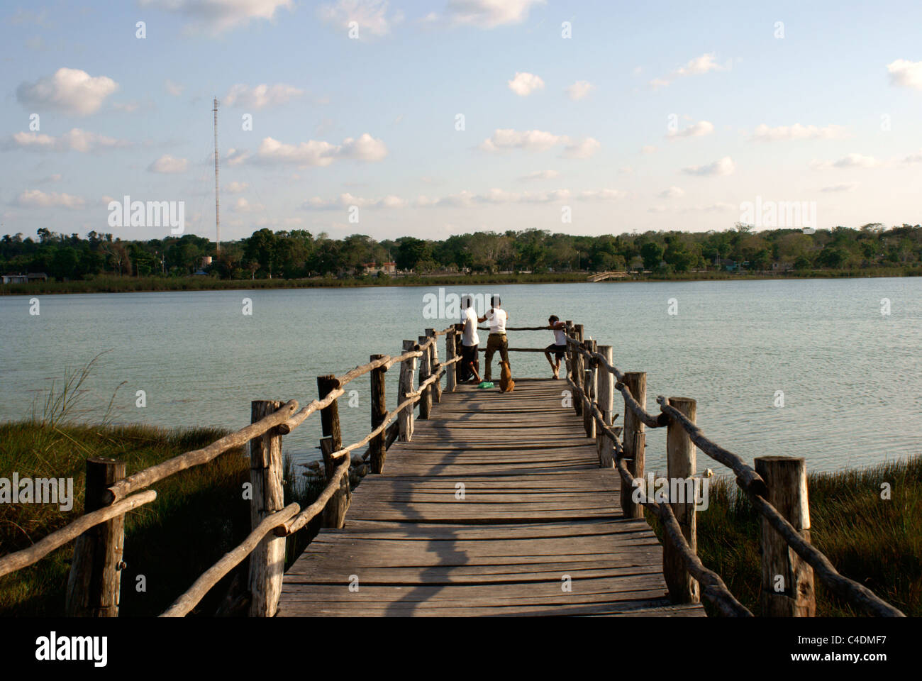 Garçons pêchant sur un quai sur le lac Coba ou Laguna Cobá en arrière-plan, Coba, Quintana Roo, Mexique Banque D'Images