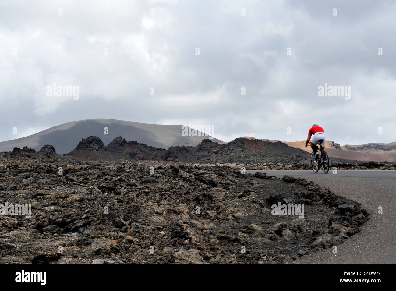 Cycliste sur route dans le parc volcanique de Timanfaya, Lanzarote, Canaries Banque D'Images