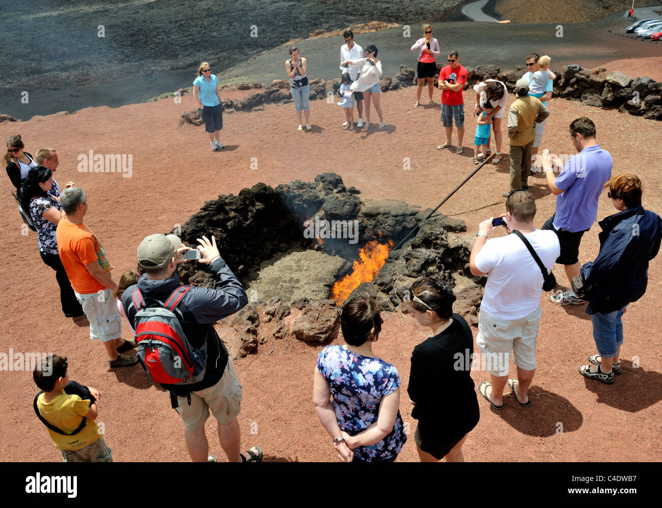 Regarder les touristes ont mis le feu à la chaleur volcanique lichen sec Parc Timanfaya, Lanzarote, Canaries Banque D'Images