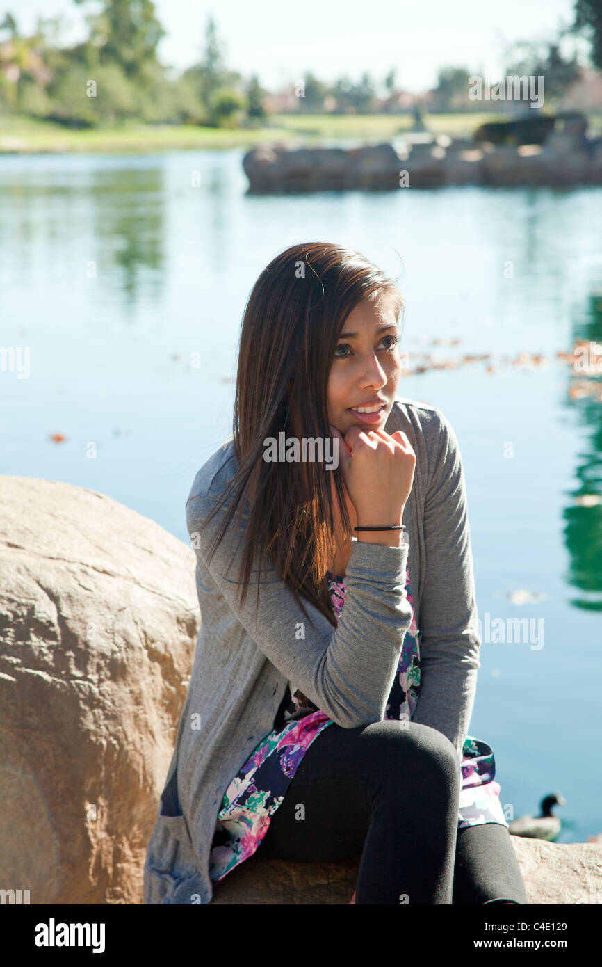 Hispanic girl sitting in nature réfléchie sérieusement penser rêver assis à méditer sérieusement monsieur © Myrleen Pearson Banque D'Images