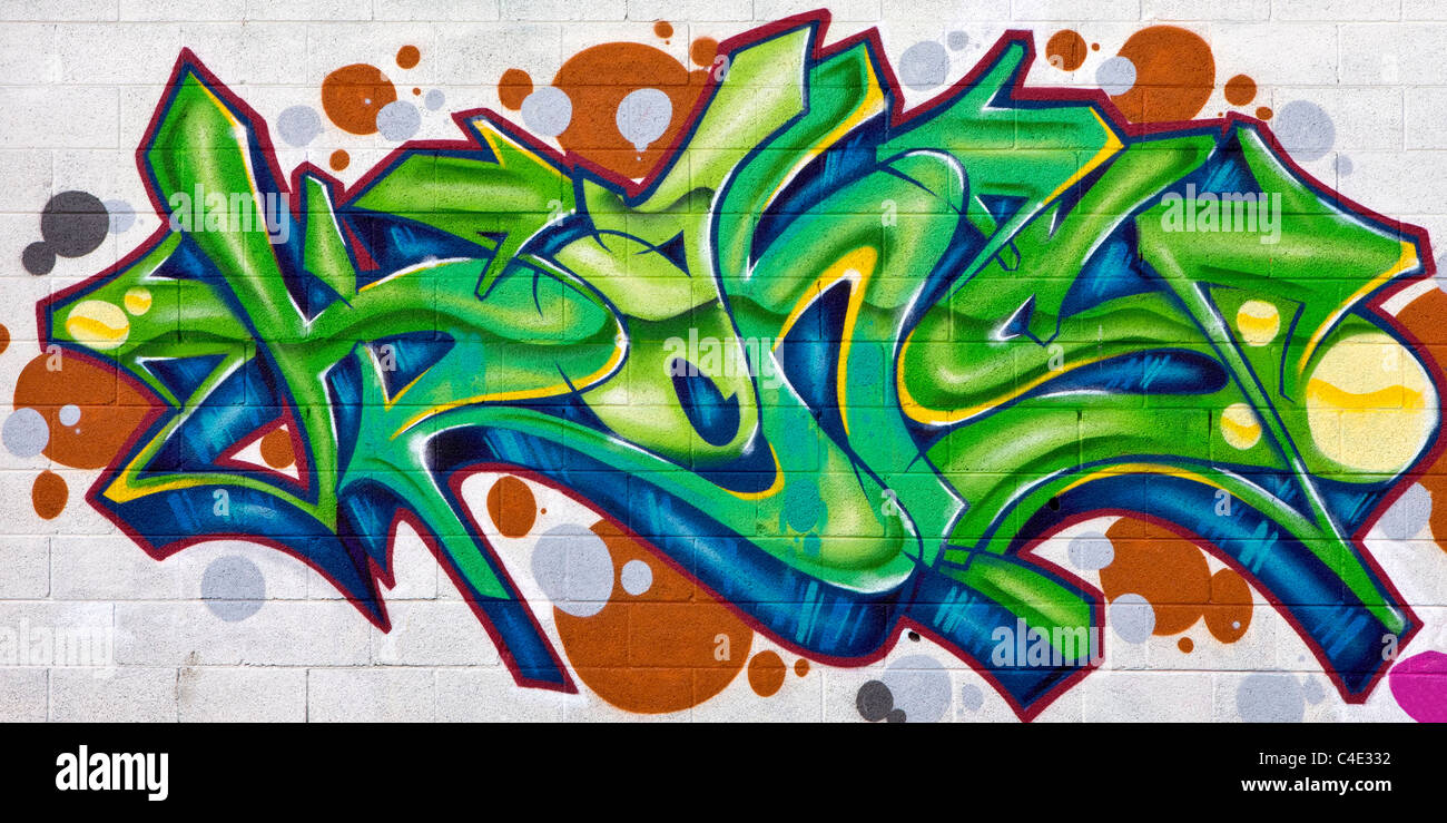 Un cadre coloré vert, bleu et orange peinture graffiti sur un mur en brique blanche Banque D'Images