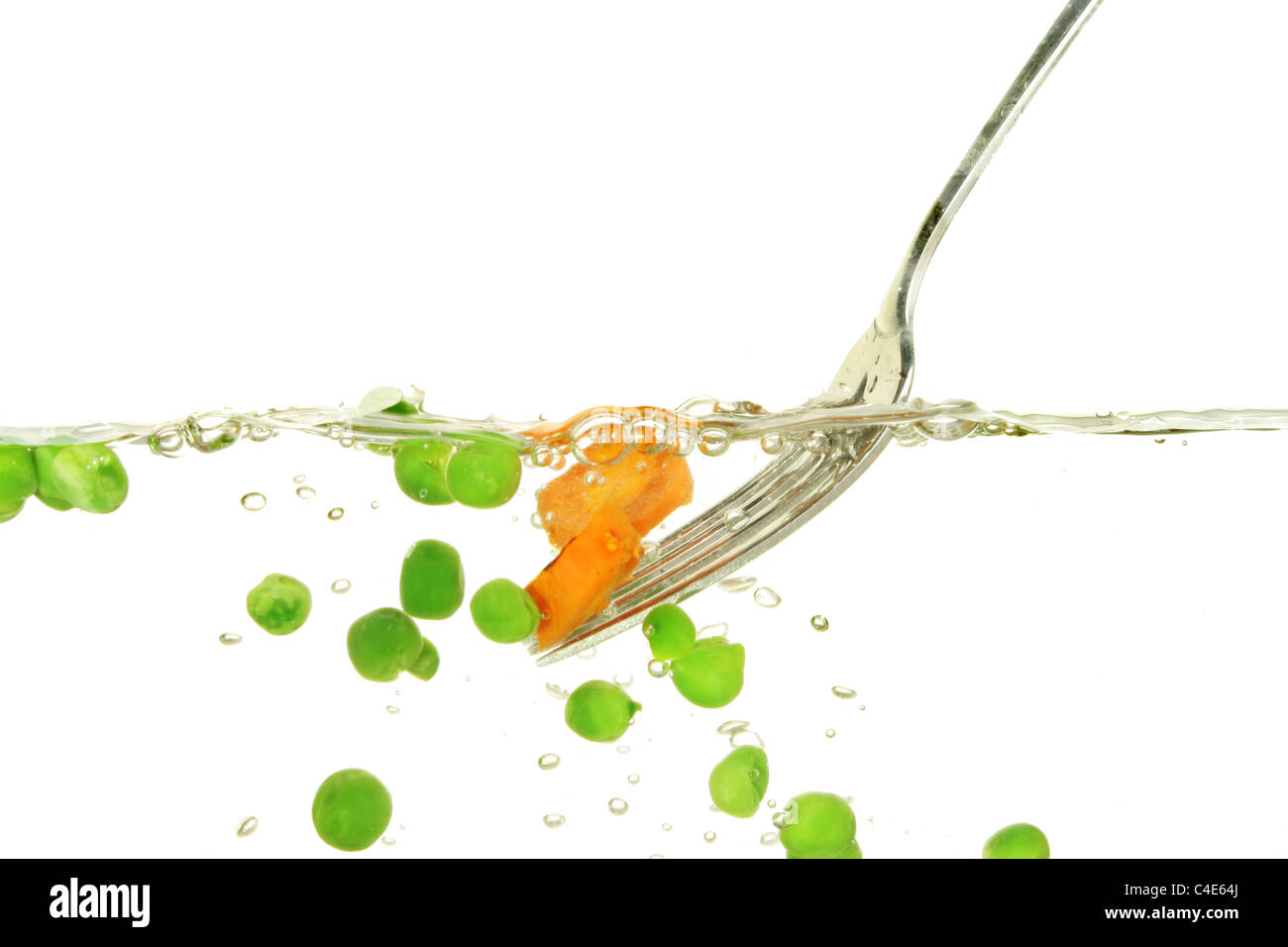 Petits pois et carottes à l'eau bouillante à l'aide d'une fourchette Banque D'Images