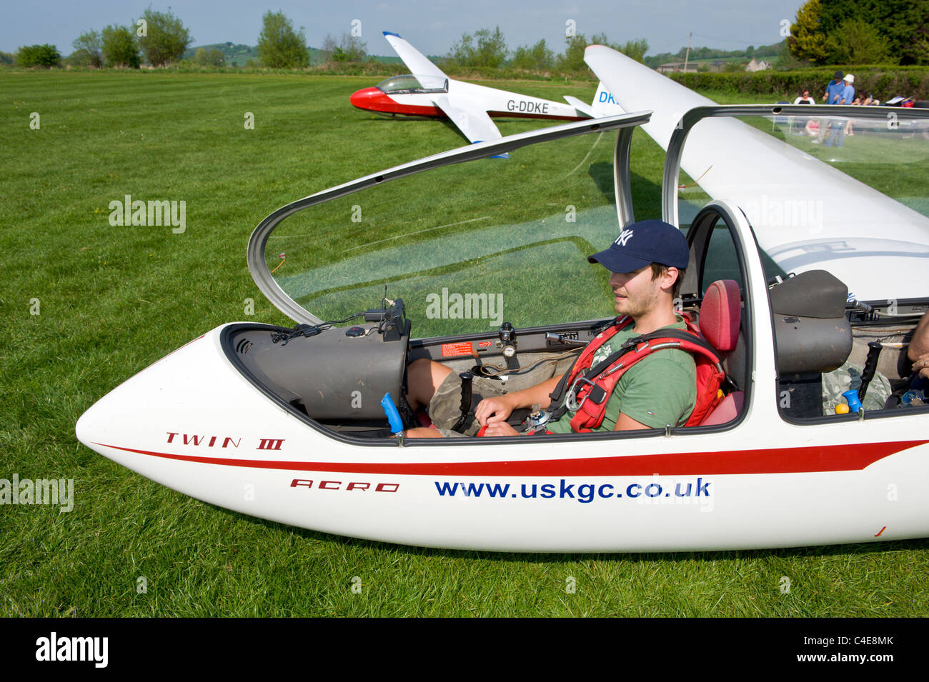 Jeune homme recevoir un enseignement sur l'aménagement du poste de pilotage avant d'avoir le premier vol en avion planeur biplace Banque D'Images