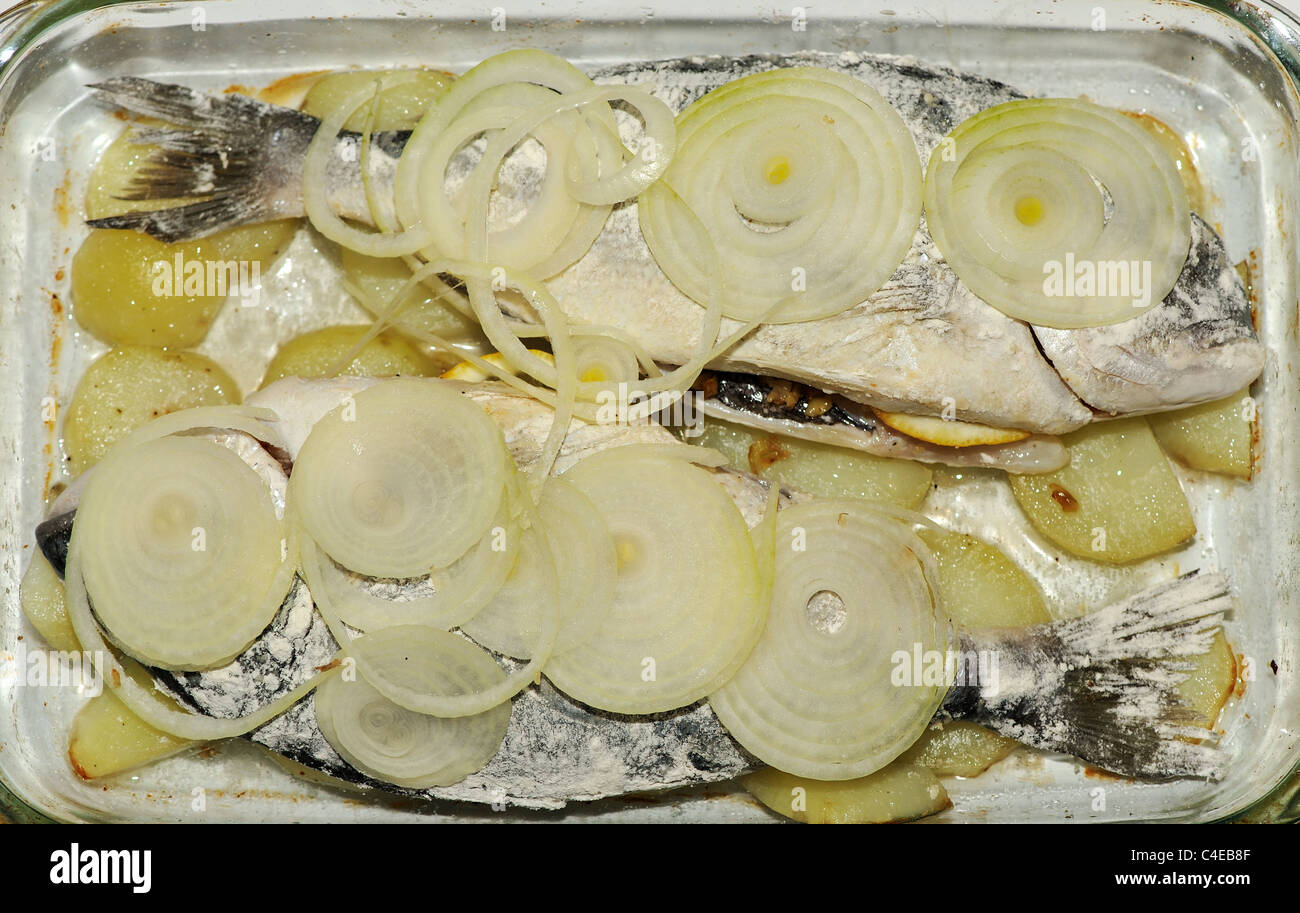 Deux Dorades de mer avec oignons et pommes de terre préparées pour la cuisson Banque D'Images