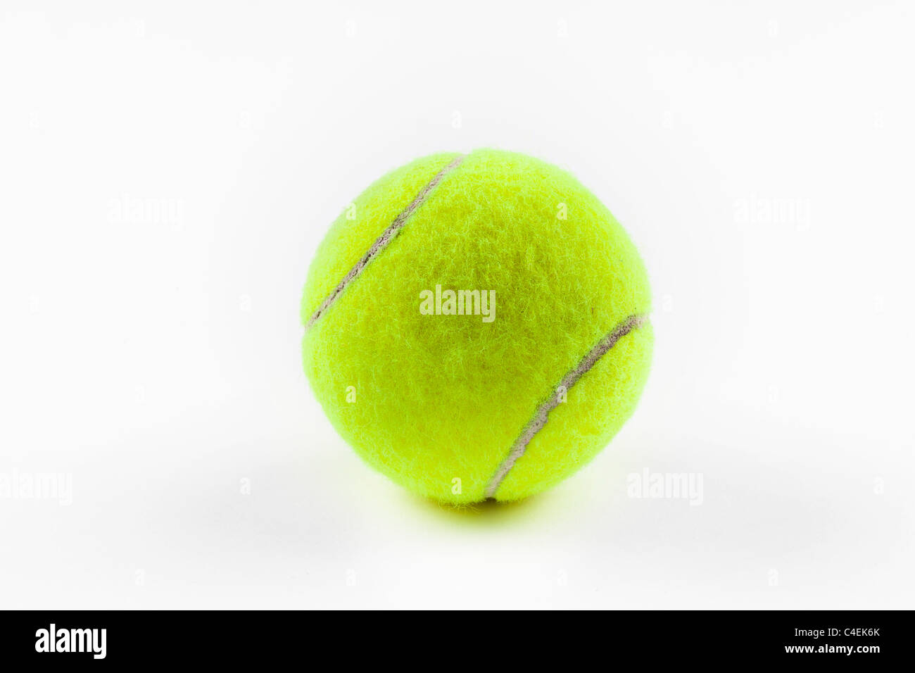 Une balle de tennis jaune sur un fond blanc. Banque D'Images