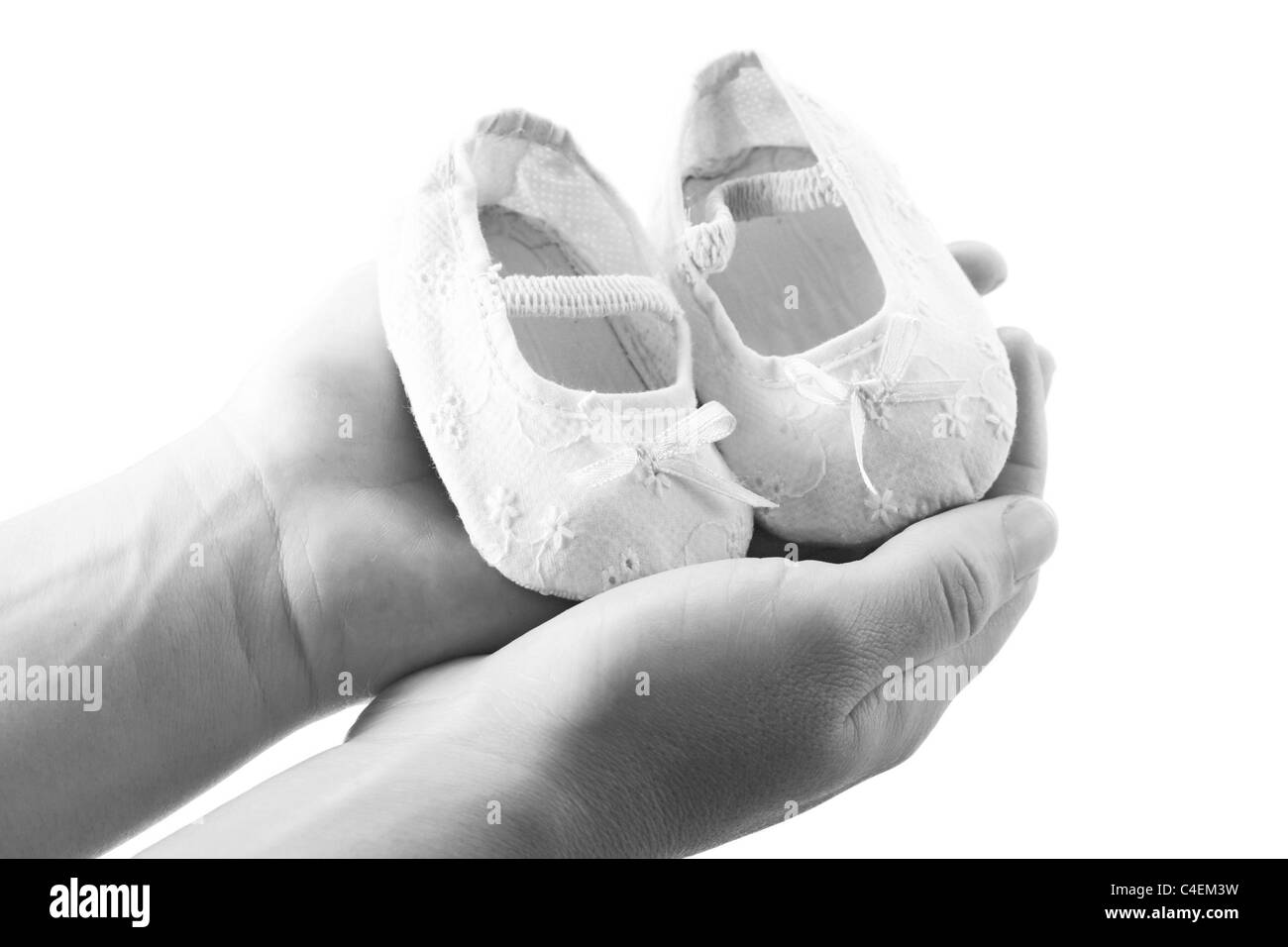 Hands holding newborn baby shoes Banque D'Images