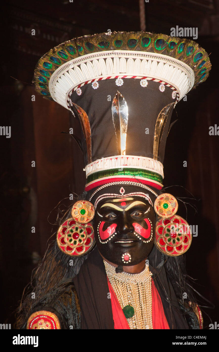 Acteur dans un miroir dans un Kathkali danse classique-drame avec couleur de fond montrant qu'il est un démon.Kerala, Inde Banque D'Images