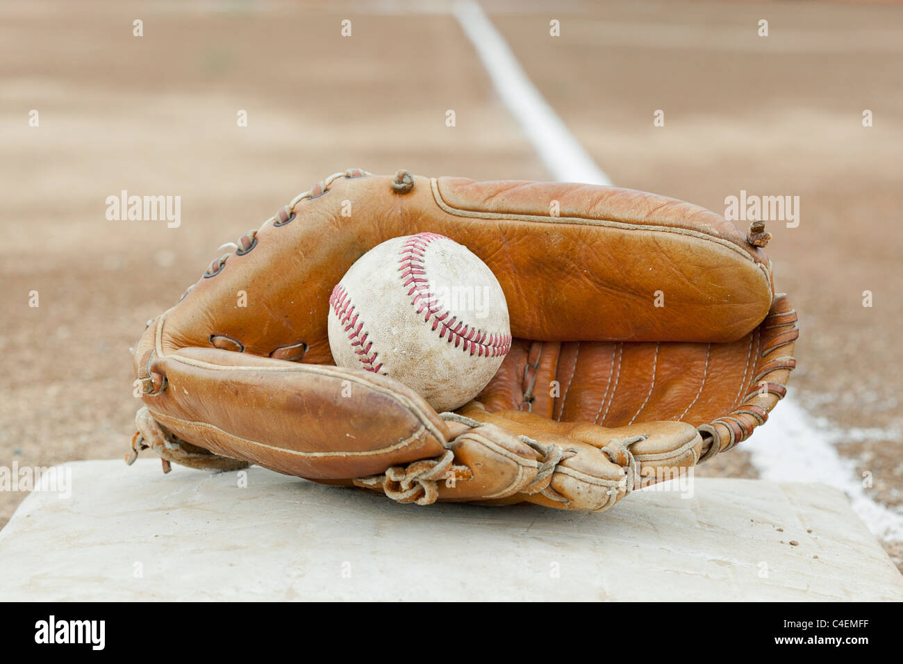 Une vieille porte un gant de baseball et balle sur un terrain de baseball Banque D'Images