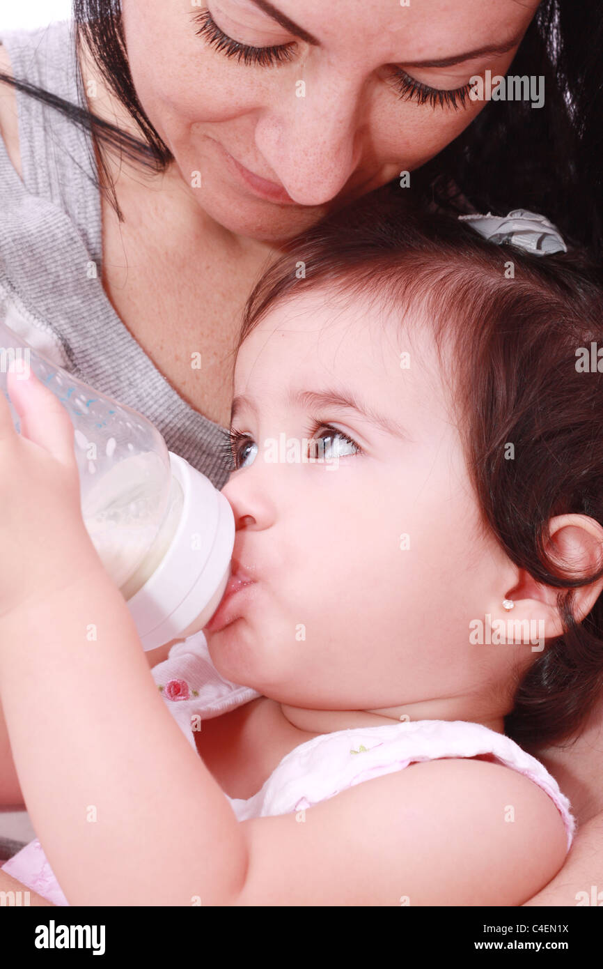 La mère et l'enfant le lait de consommation à partir de la bouteille dans un fond blanc Banque D'Images