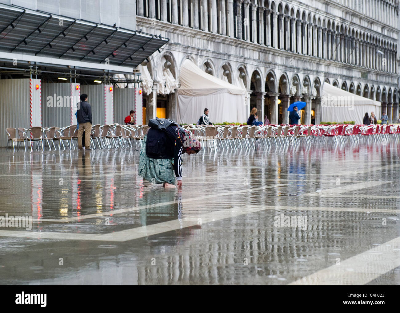 Un mendiant dans la place San Marco au cours d'acqua alta Venise Italie Juin 2011 Banque D'Images