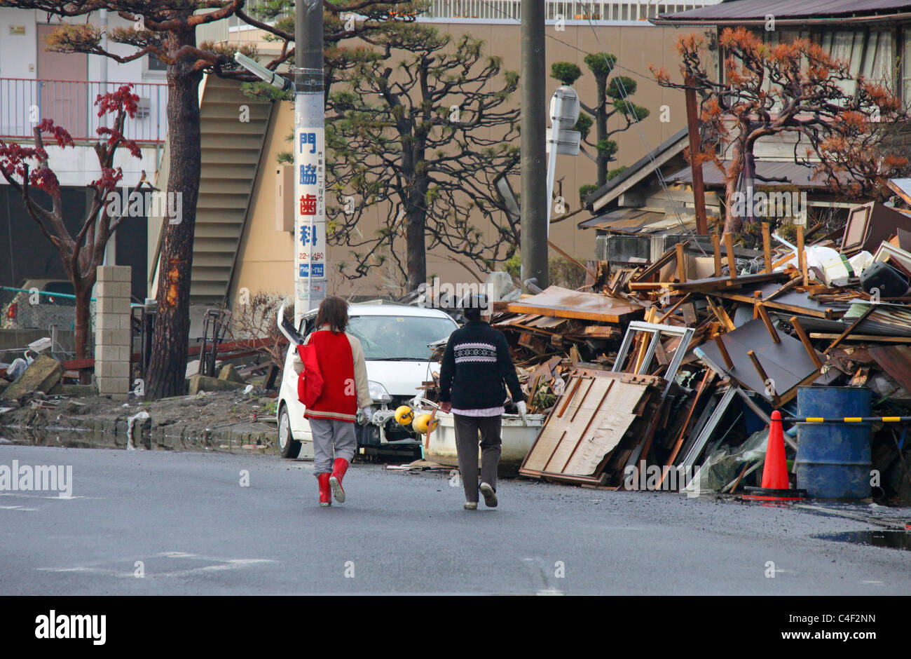 Les gens se promener dans une ville dévastée par le tsunami du 11 mars 2011 Ishinomaki Japon Miyagi Banque D'Images