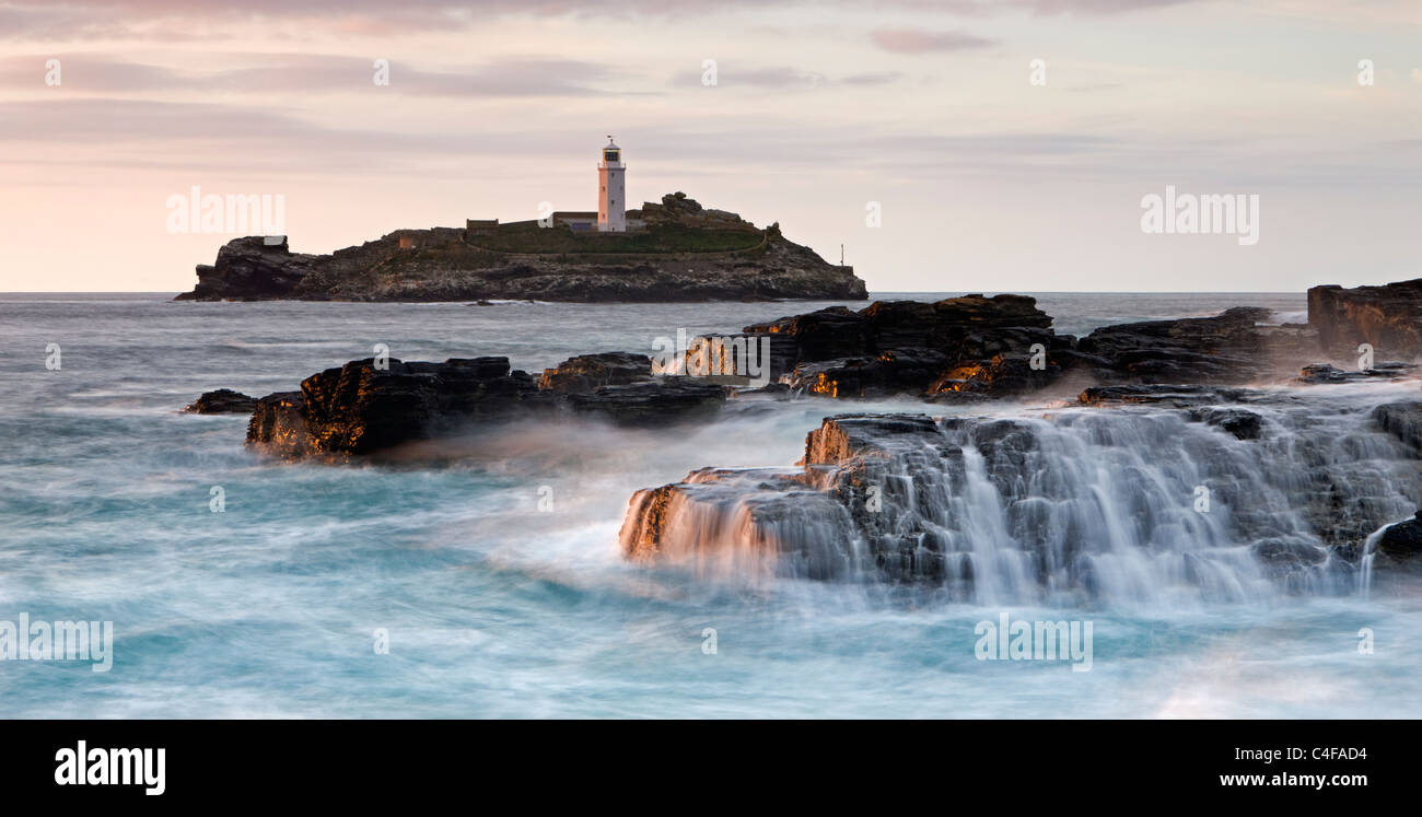 Les vagues déferlent sur les rochers au Godrevy Point, à l'extérieur, vers le phare sur l'île de Godrevy, Cornwall, Angleterre. Banque D'Images