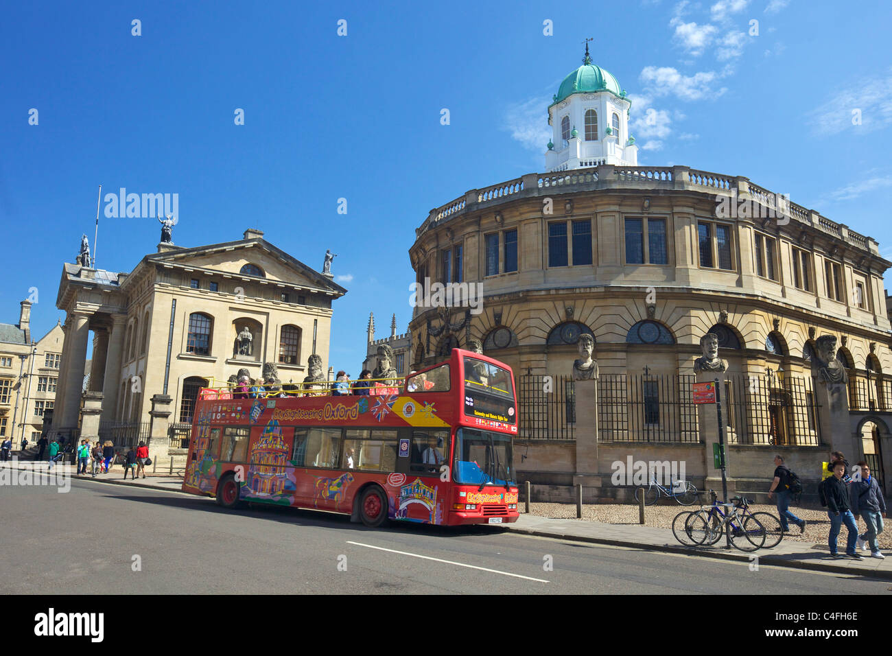 Open-top bus touristique hors Sheldonian Theatre et Clarendon Building, Broad Street, Oxford University, Centre-ville, l'Oxfordshir Banque D'Images