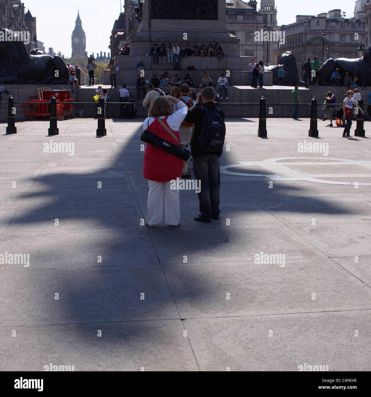 Les touristes se cacher de la lumière du soleil et de la chaleur tout en prenant une photo de Nelsons Column à Trafalgar Square Banque D'Images