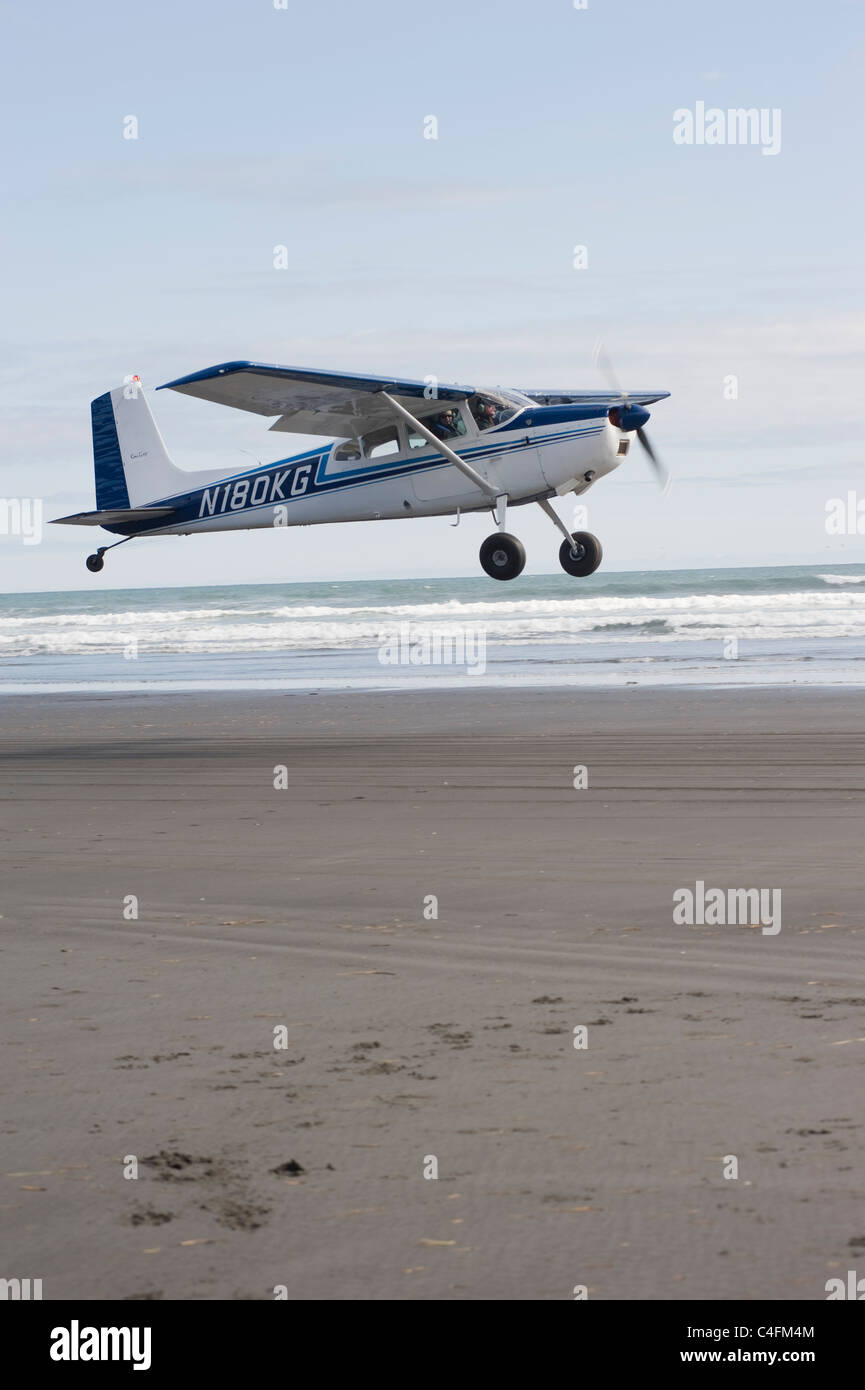 Cessna 185 décollant de la plage sur l'île de Hinchenbrook, Prince William Sound, Alaska Banque D'Images