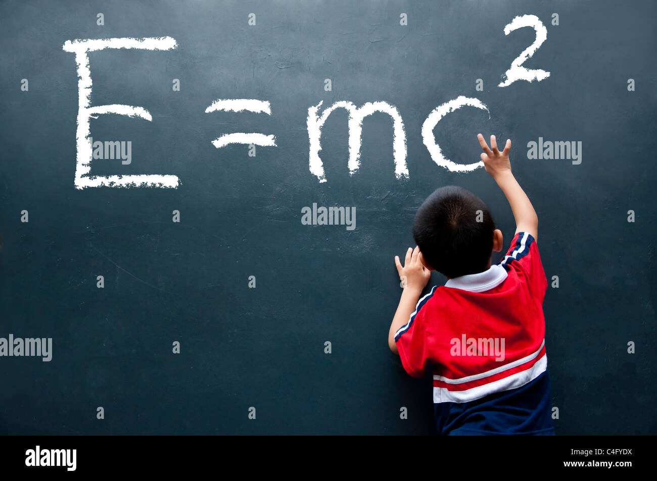 Boy drawing E =mc2 sur le mur Banque D'Images