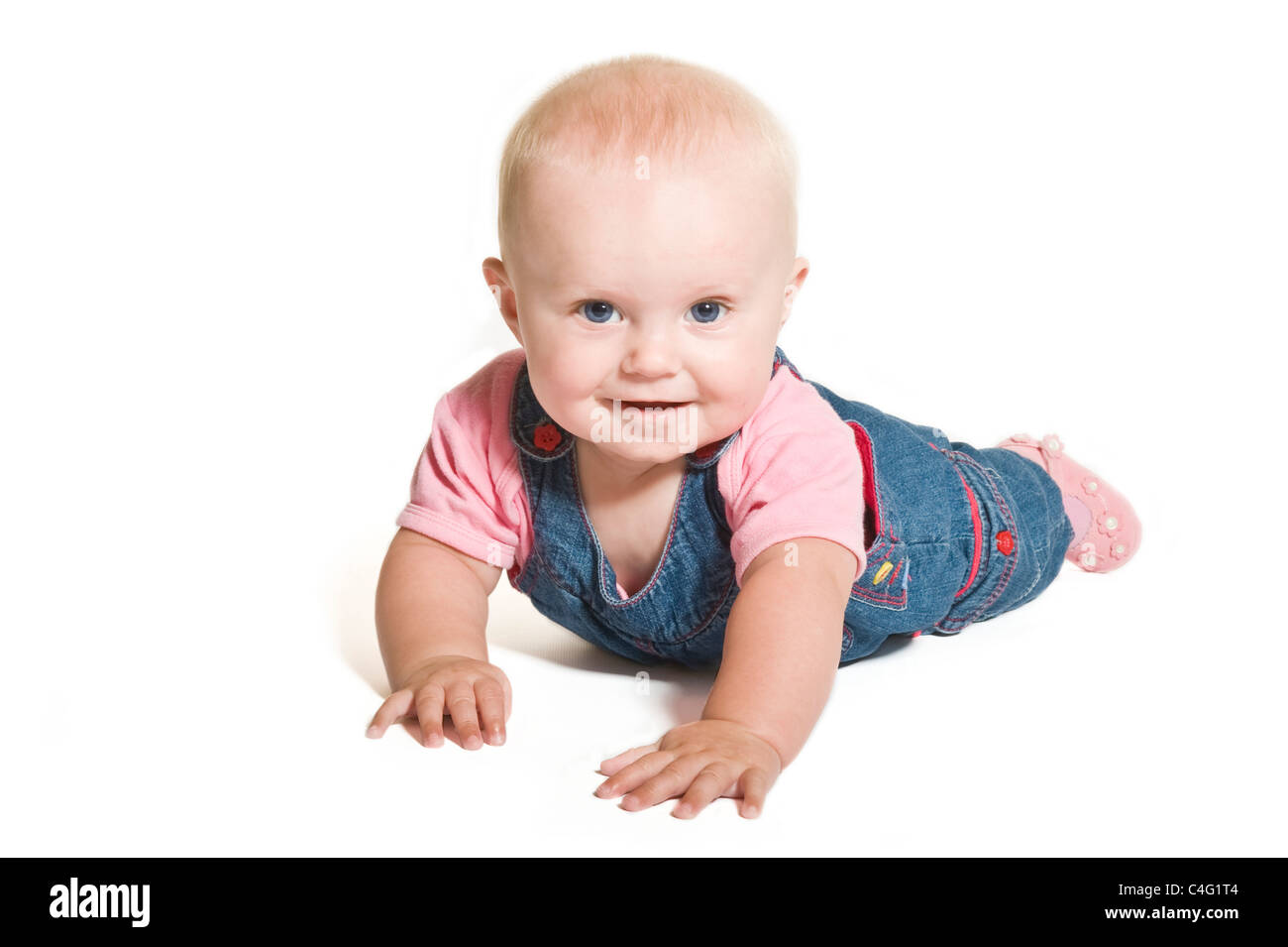 Un mignon bébé de 1 an fille aux yeux bleu denim et porter contre un sourire rose blanc pur (255) Contexte. Banque D'Images