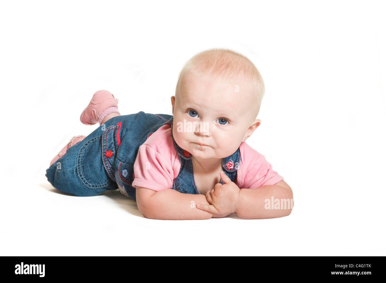 Un mignon bébé de 1 an fille aux yeux bleu denim et porter contre un sourire rose blanc pur (255) Contexte. Banque D'Images