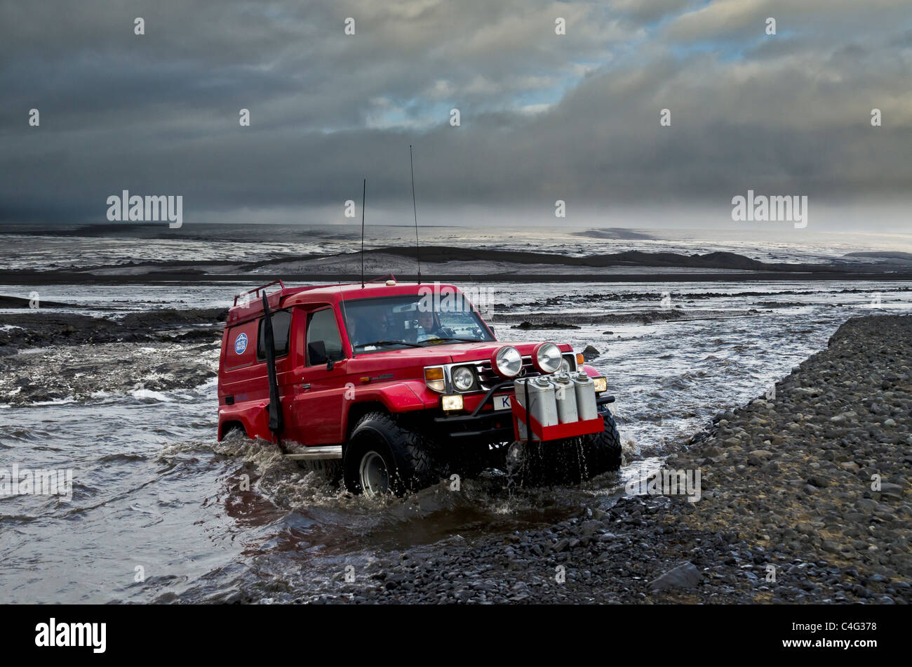 Big Red traversant la rivière glaciaire Tungnaa rempli de cendres de l'éruption volcanique en Islande, Grimsvotn Banque D'Images