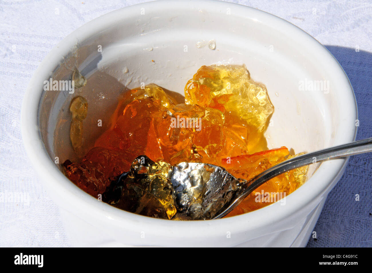 Marmelade d'Orange dans un plat de céramique blanche avec une cuillère en argent. Banque D'Images