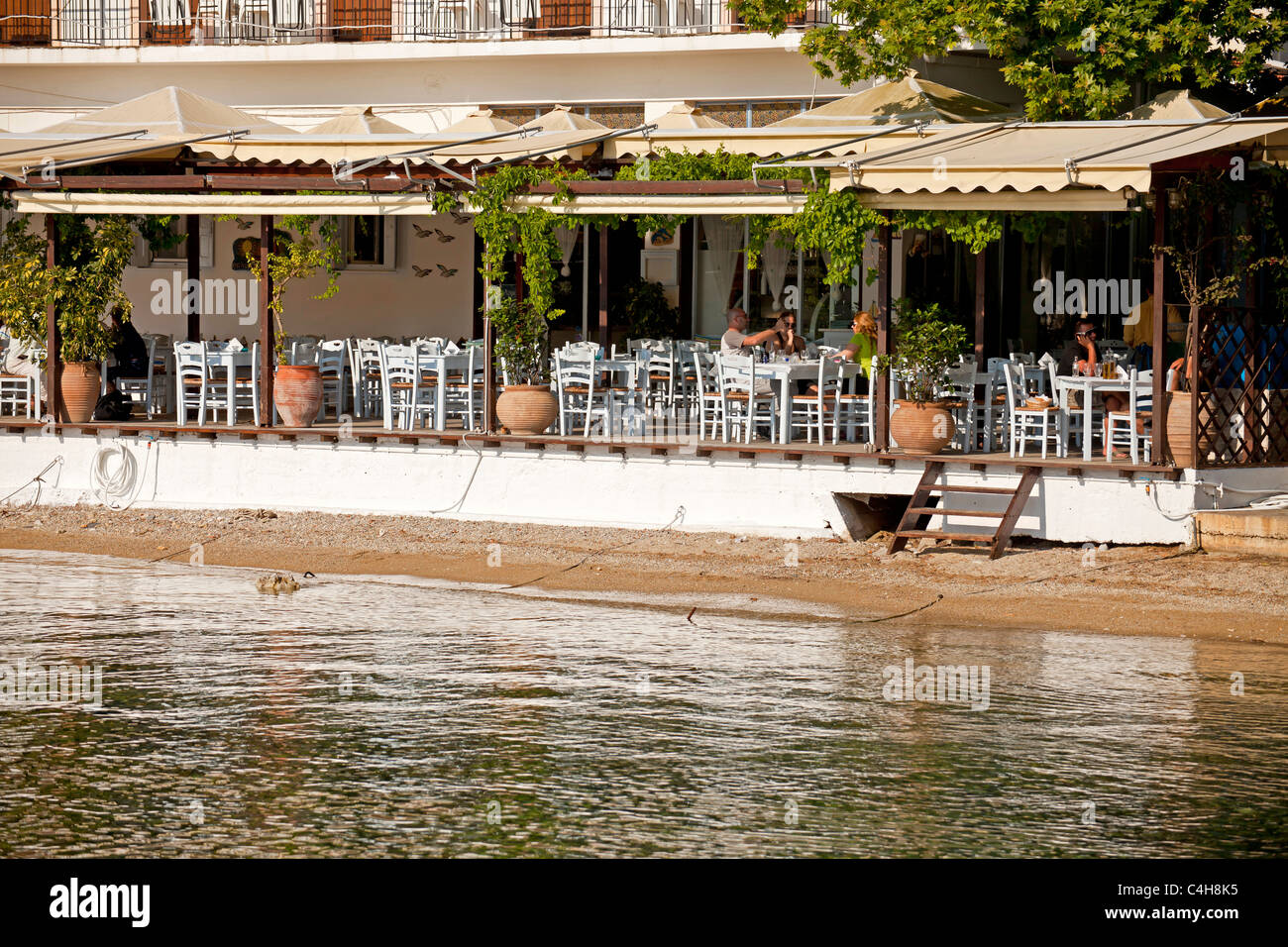 Populaires restaurants de poisson à la plage dans le petit village de pêcheurs de Agnondas, île de Skopelos, Sporades du Nord, Grèce Banque D'Images