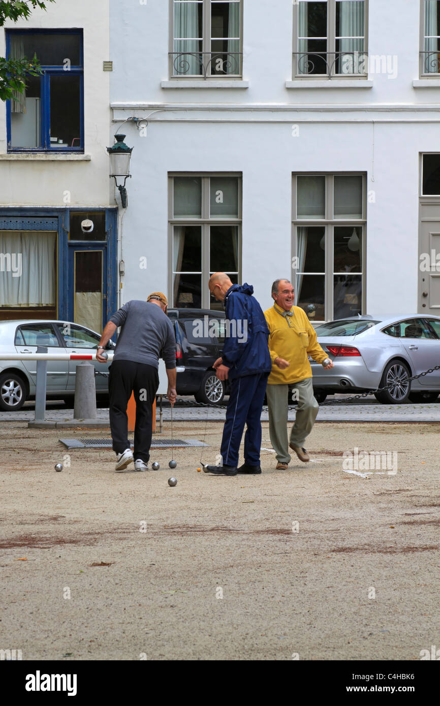 Les hommes belges profitez d'un jeu de boules sur une place de Bruges Banque D'Images