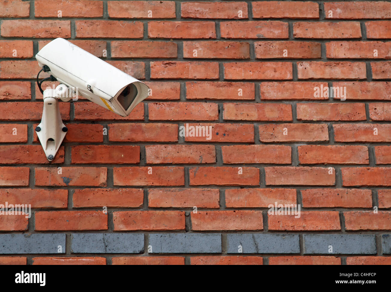 Caméra CCTV blanc monté sur un mur de brique rouge Banque D'Images