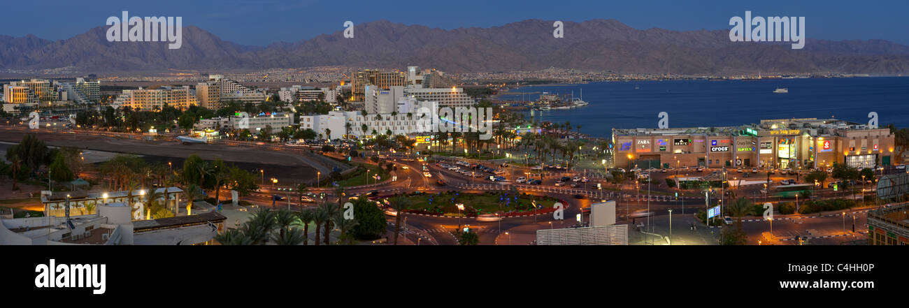 Photo 4 une croix vue panoramique de l'hôtel et la plage d'Eilat dans la soirée avec les lumières d'Aqaba à l'arrière-plan Banque D'Images