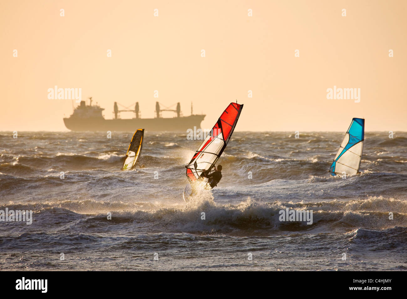 Navire et trois planches à voile Planche à voile sur la mer du Nord au coucher du soleil Banque D'Images