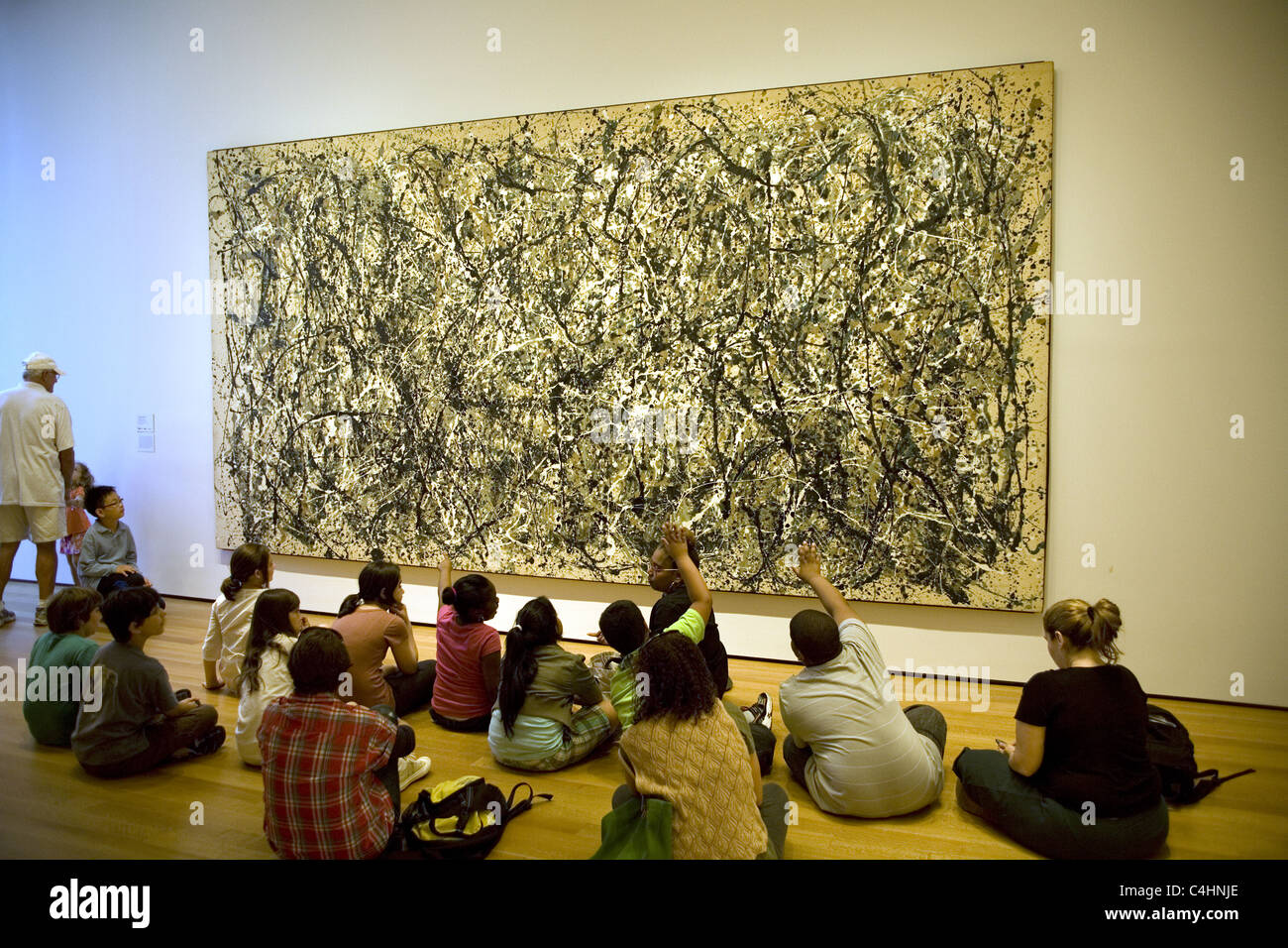 Les enfants de l'école de discuter d'une peinture de Jackson Pollock au Musée d'Art Moderne (MOMA) à New York. Banque D'Images
