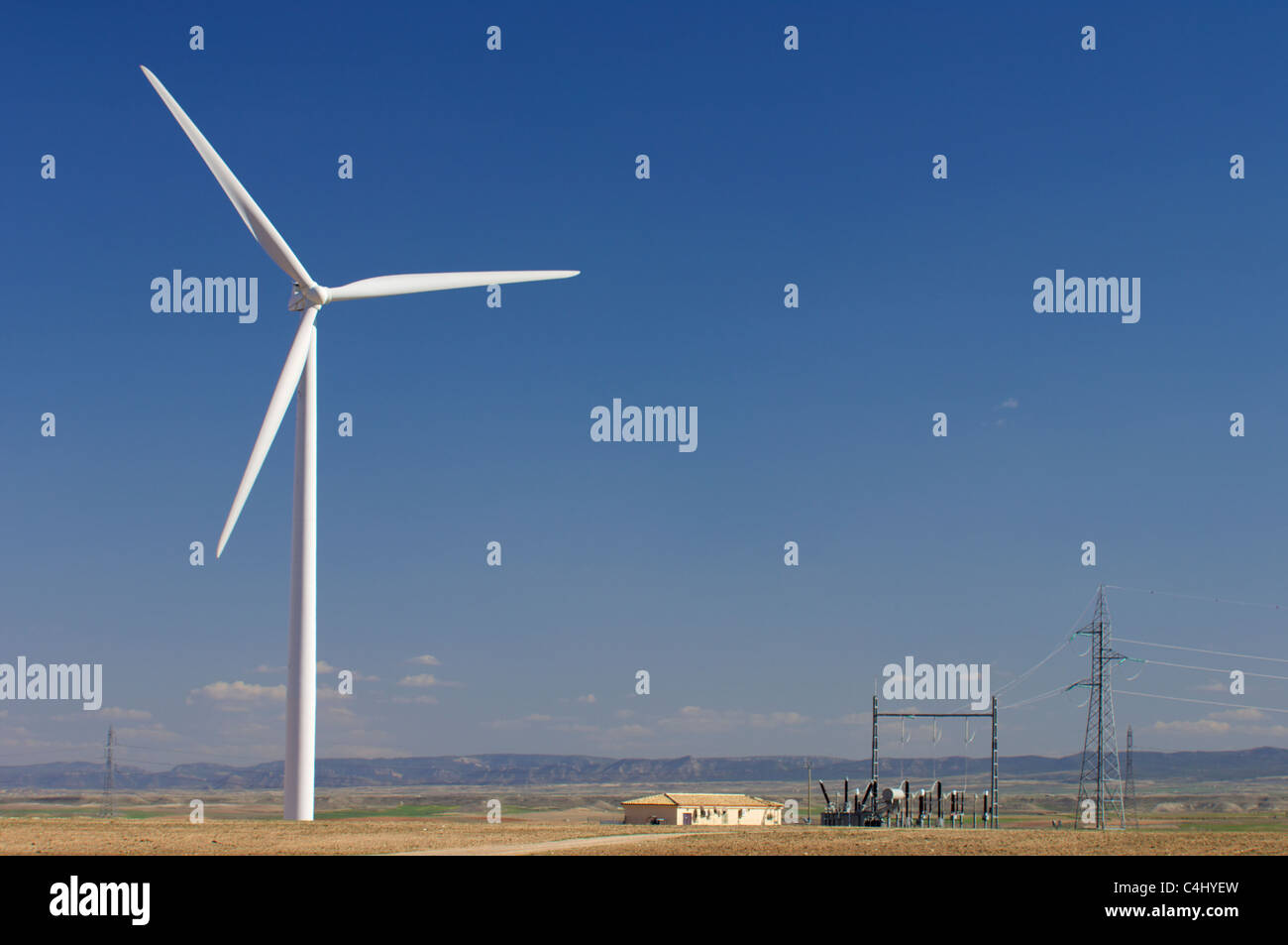 Poste électrique haute tension et moulin à vent avec ciel bleu Photo Stock  - Alamy