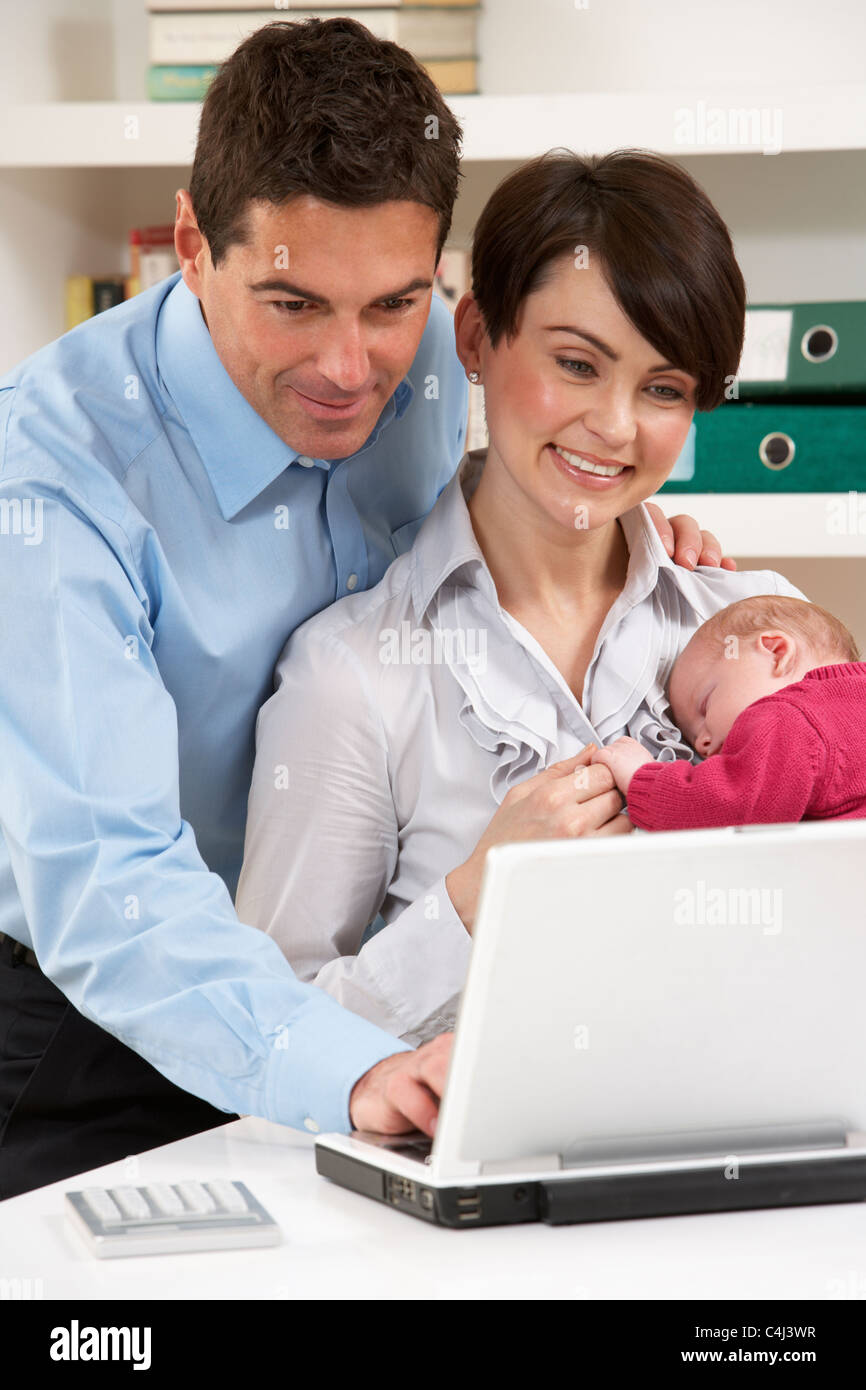 Les parents de nouveau-né à domicile Using Laptop Banque D'Images