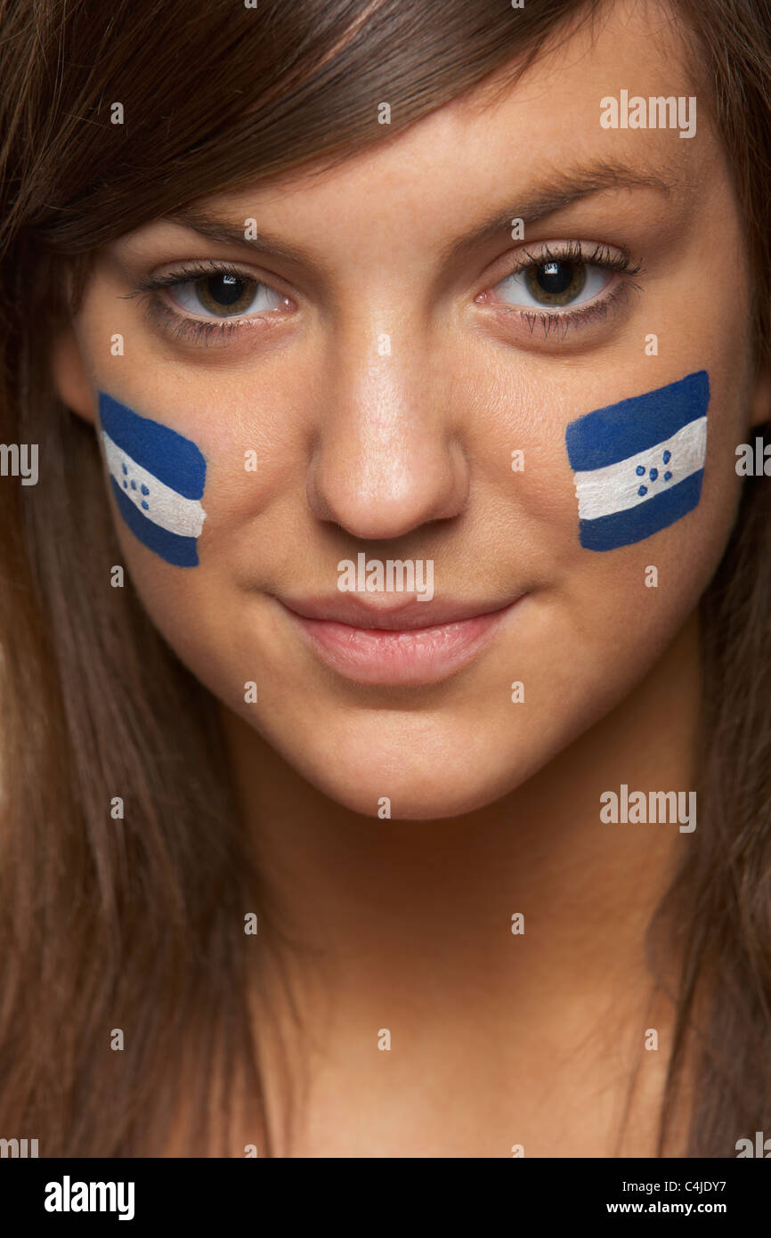 Jeune femme fan de sport avec drapeau hondurien sur le visage peint Banque D'Images