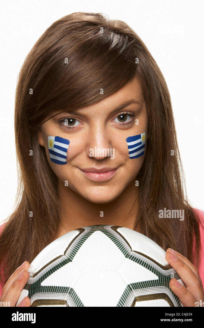 Les jeunes fans de football féminin avec drapeau uruguayen a peint sur le visage Banque D'Images